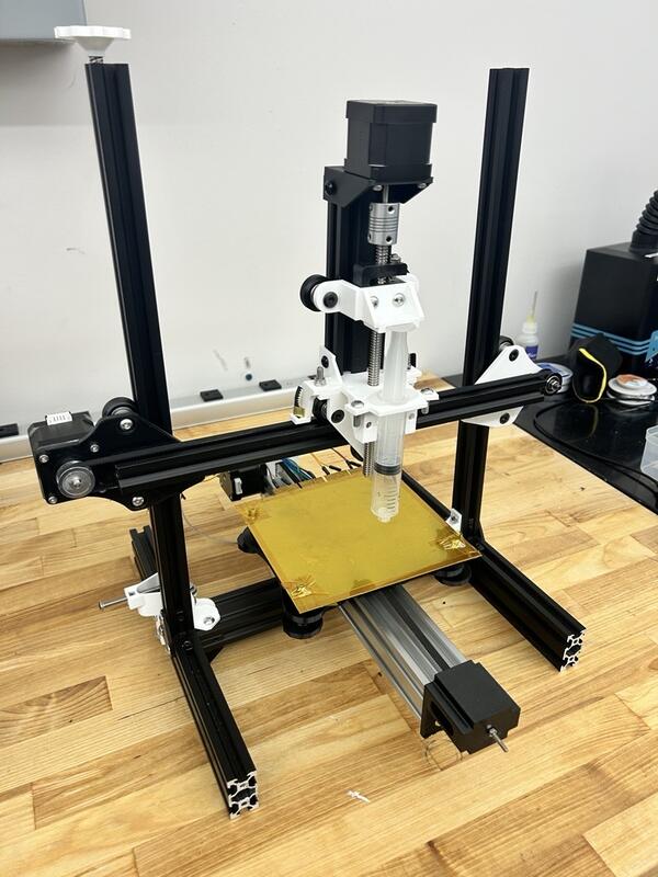 Stepper-driven syringe assembly for liquid-metal distribution